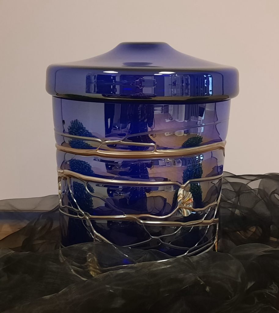 Blaue handgefertigte Glasurne. Da sich Glas nicht abbauen lässt, ist dies keine Urne aus Naturstoff.